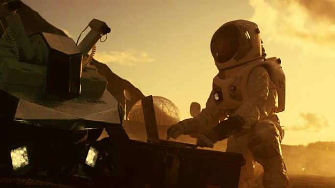 宇航员穿着宇航服在一台笔记本电脑上工作，在一个新的外星红色星球/火星上调整火星车。日光高科技太空探索