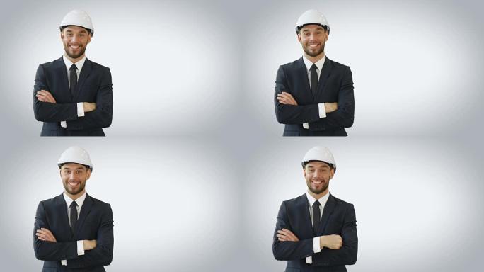 一个商人戴着安全帽，微笑着双手交叉。在白色背景上拍摄。