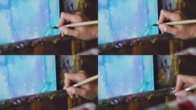 年轻的女艺术家用水彩画画，并在完成特写上写下她的签名
