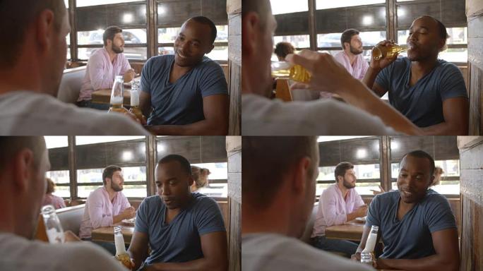 两个男性朋友在聊天，用啤酒瓶敬酒