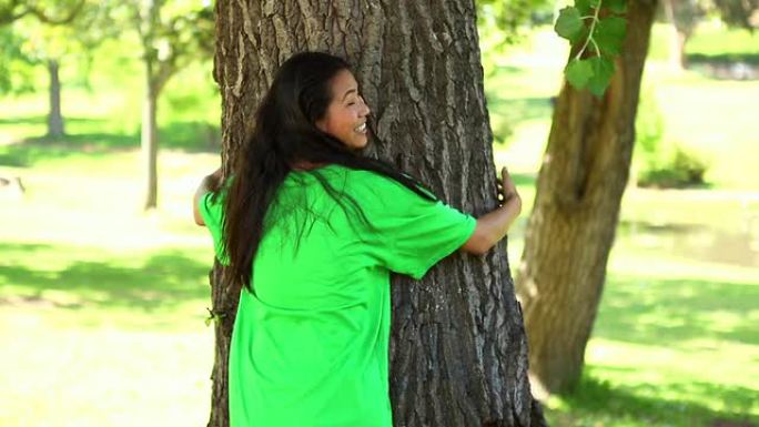 快乐的环保主义者拥抱一棵树