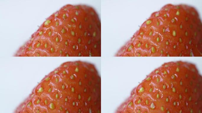 特写: 甜红色草莓果实中的小种子的细节。在浆果上下雨