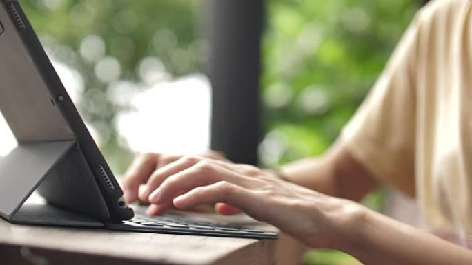年轻女子在平板电脑键盘上打字