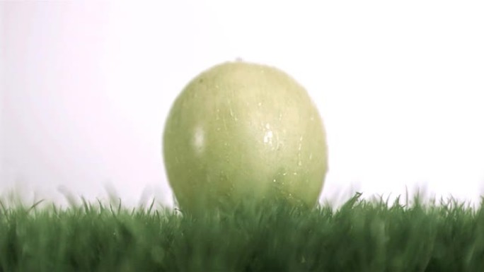 苹果在草地上以超慢动作落下