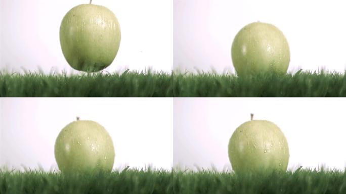 苹果在草地上以超慢动作落下