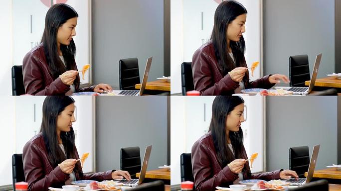 在4k餐厅使用笔记本电脑时吃寿司的女人