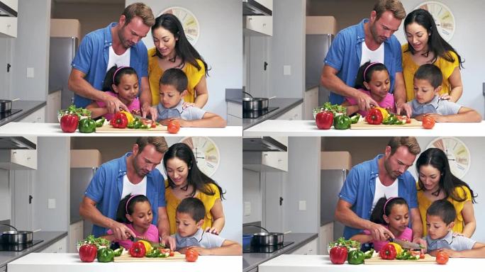 可爱的家庭在厨房里切蔬菜