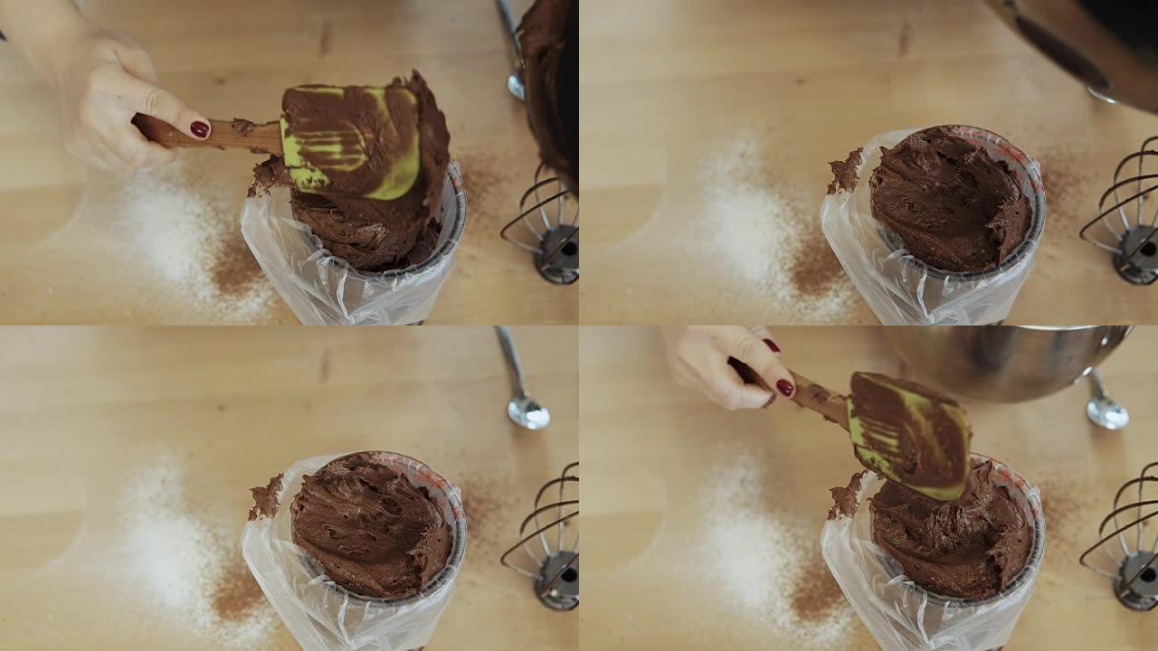 女性双手将巧克力奶油或面团放入糕点袋的特写镜头。女人在厨房做饭