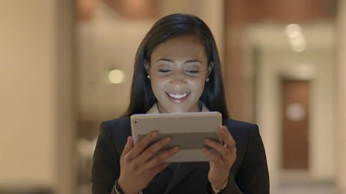 年轻迷人的黑人女性使用平板电脑在线搜索网络。穿着西装的非洲裔美国女性与社交媒体联系。城市生活背景