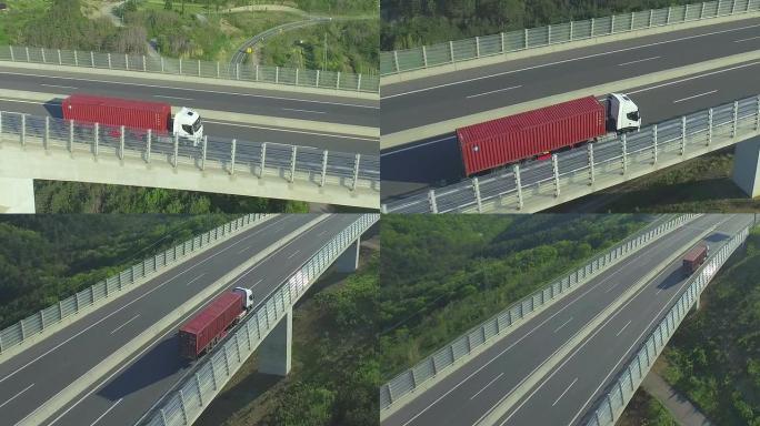空中: 在高速公路高架桥上行驶的集装箱卡车