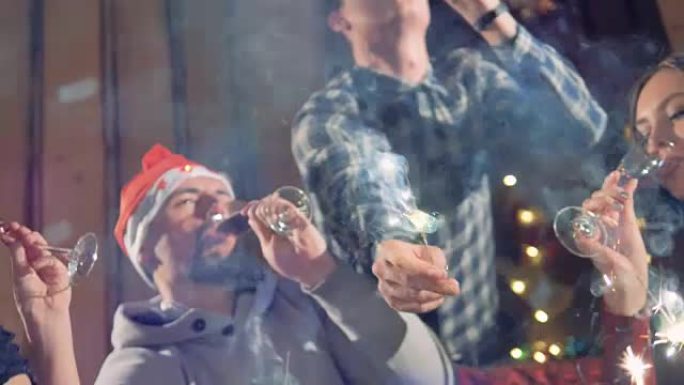 用葡萄酒和烟火庆祝圣诞节的人们的特写镜头。