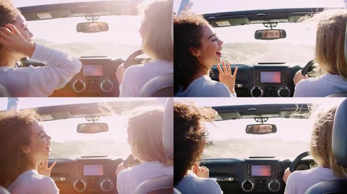 两个快乐的年轻女性开着天窗开车