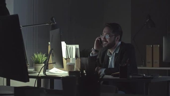 企业家在黑暗的办公室里通电话
