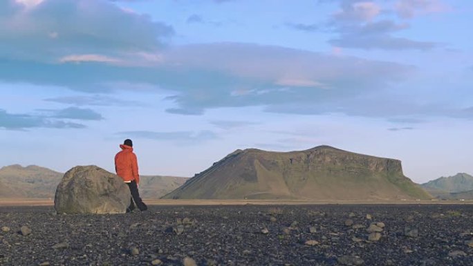 徒步旅行者在冰岛的一块岩石上休息
