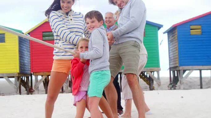 多代家庭在海滩上拉锯战