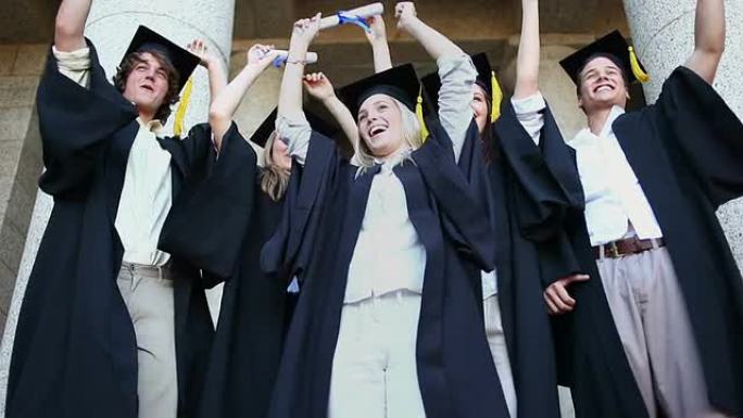 快乐毕业的学生举起手臂