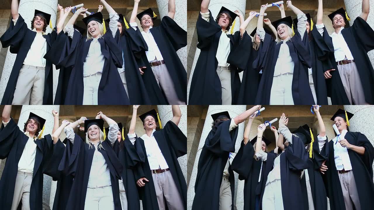 快乐毕业的学生举起手臂