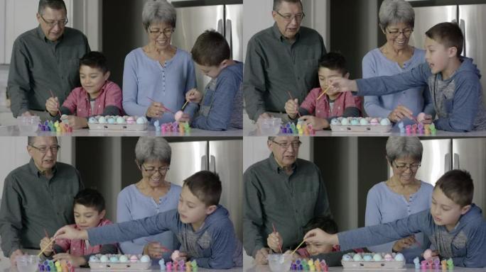 民族祖父母与两个年轻的孙子一起画复活节彩蛋