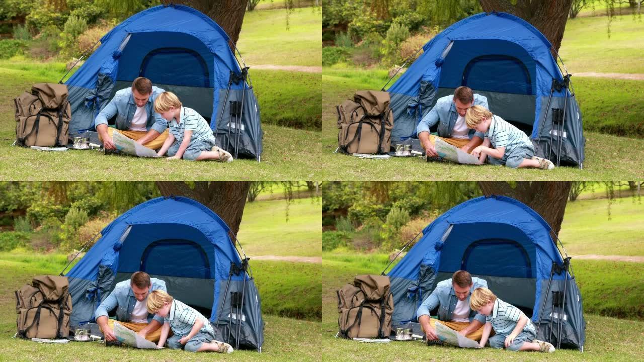 父子俩在帐篷前看地图