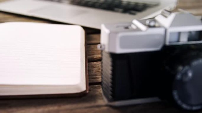 木制桌子上的笔记本电脑、日记和老式相机4k