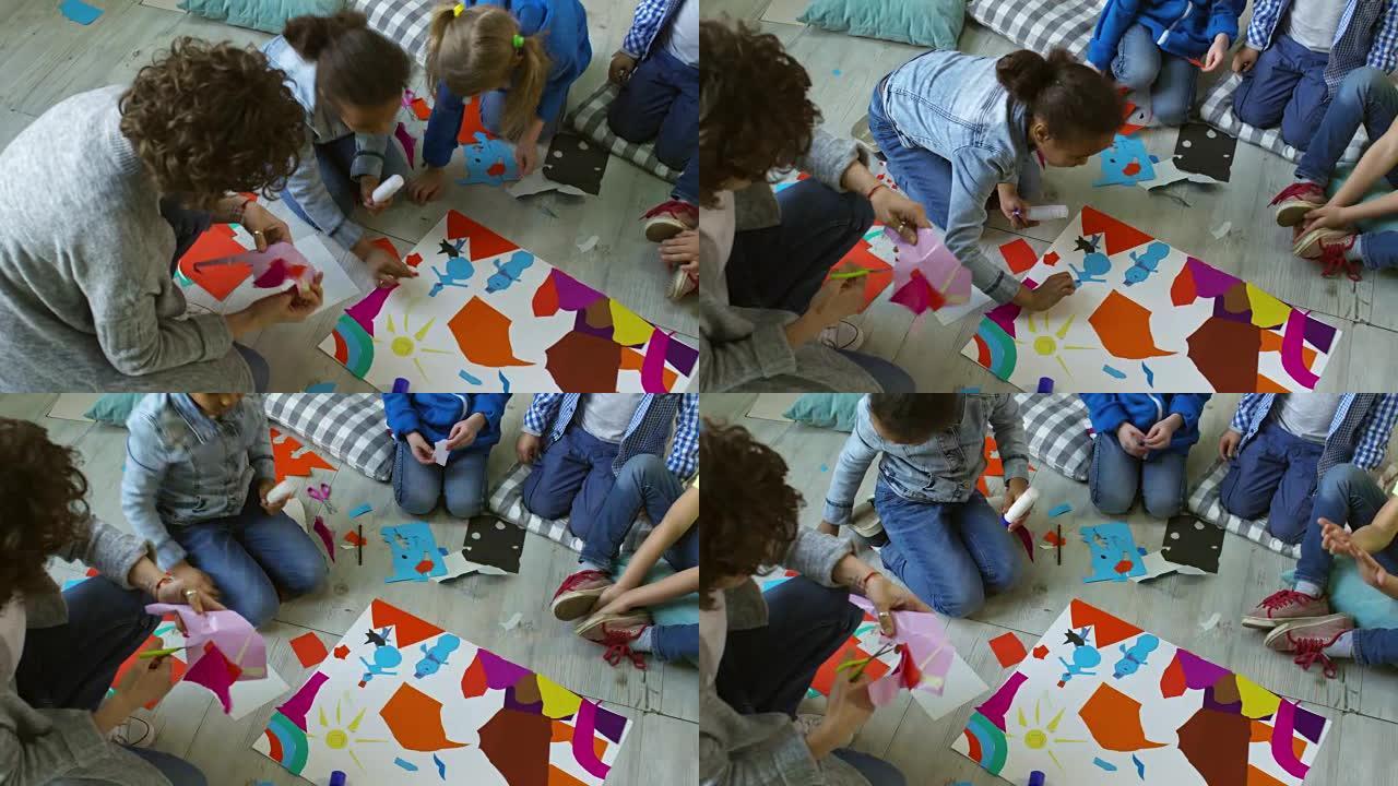 学龄前儿童与女老师一起创作彩色纸质拼贴画