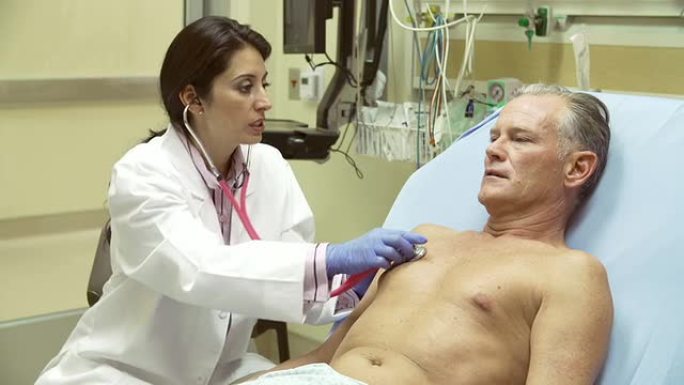 医生在医院病床上检查成熟的男性患者