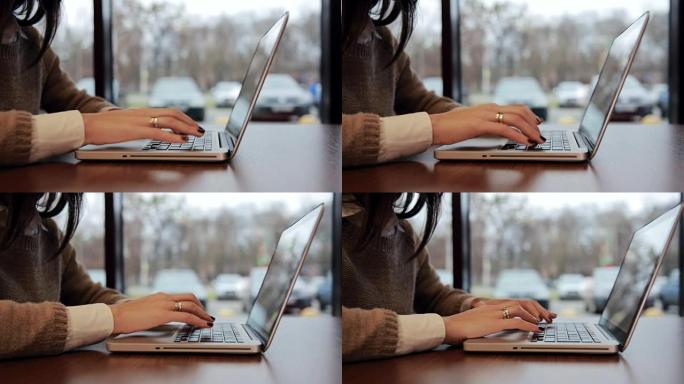 咖啡馆里的女性手在笔记本电脑上工作。向左滑动