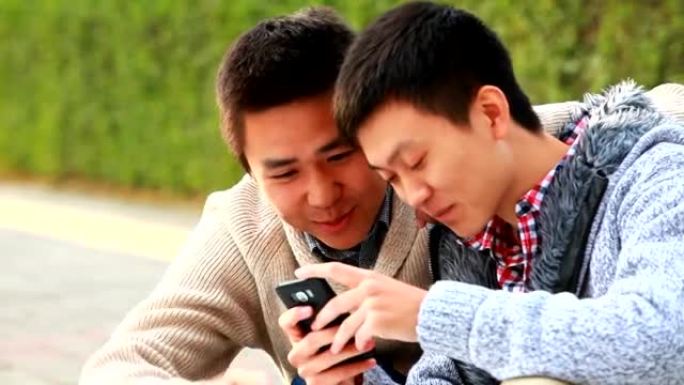 两名年轻男子一起使用手机的视频