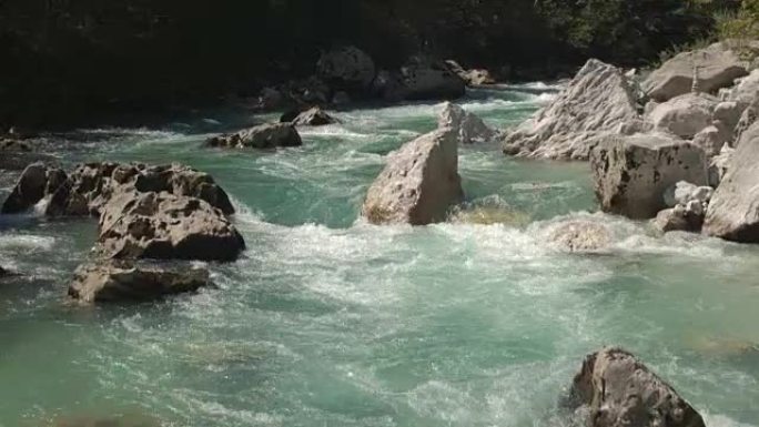 空中，特写: 令人惊叹的翡翠保持河流在大石头之间快速奔跑