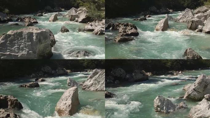空中，特写: 令人惊叹的翡翠保持河流在大石头之间快速奔跑