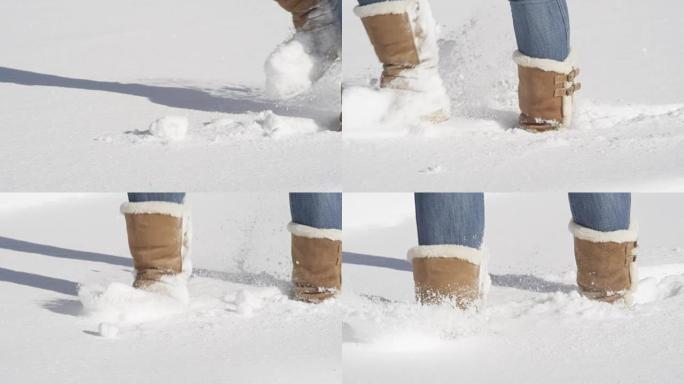 特写: 无法识别的女孩穿着冬靴走在新鲜的未触及的雪中
