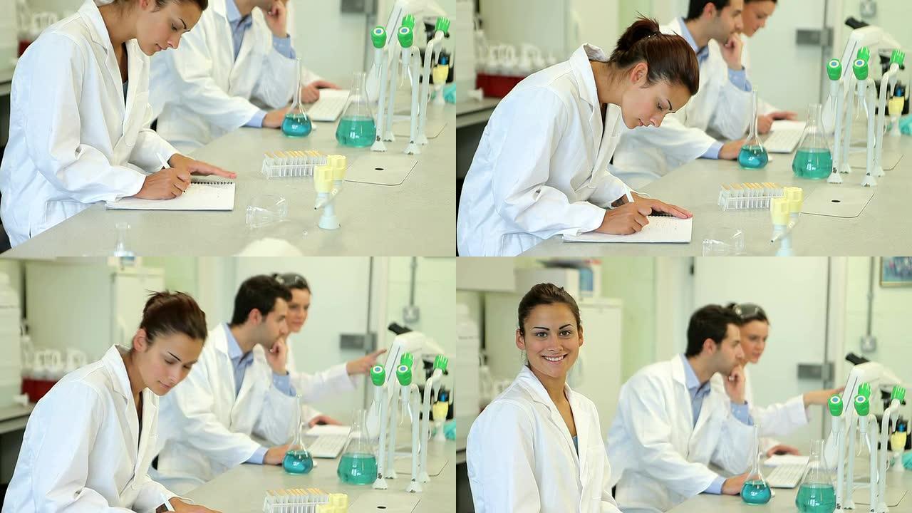化学学生从工作中抬头微笑