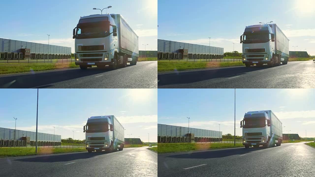 带有货运拖车的白色半卡车在工业区空旷的道路上移动，背景是阳光普照。