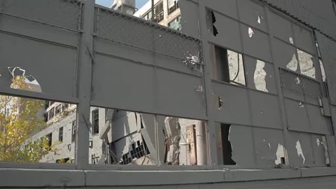 特写: 废弃工厂的破损窗户、损坏的立面和摇摇欲坠的墙壁