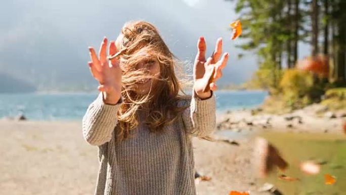 湖边的女人放开秋叶，被风吹走