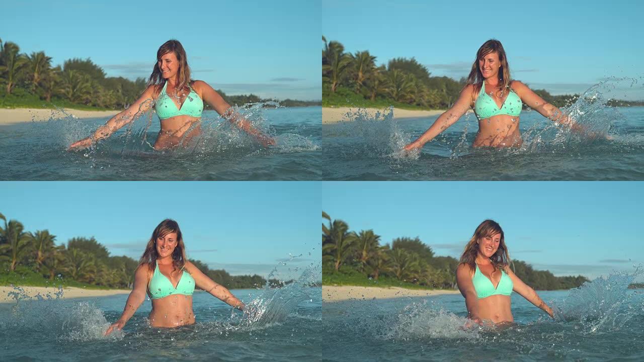 慢动作: 幸福的女人在美丽的天堂岛附近的海洋中嬉戏。