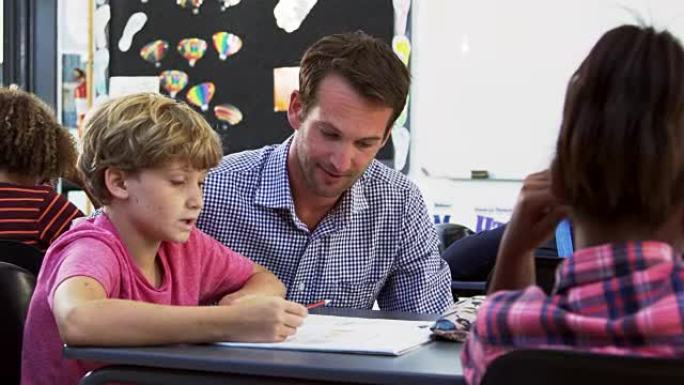 老师和年轻的男生在课堂上看着笔记本