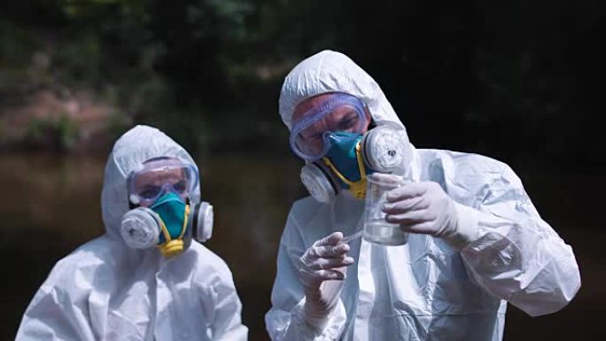 两名生态工作者在生物危害服中采样水