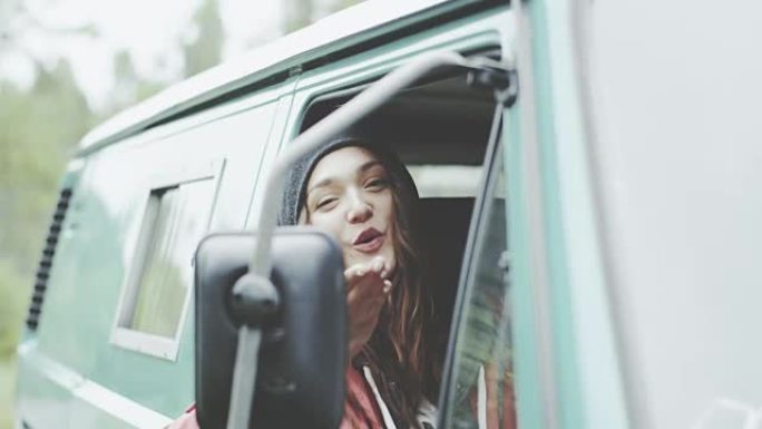 年轻女子看着车镜，做鬼脸。坐在货车里