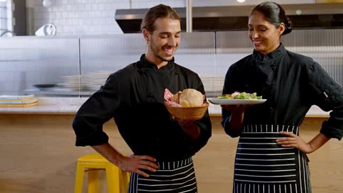 微笑的厨师在4k商用厨房展示他们的菜