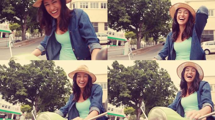 微笑的女人坐在踏板车上