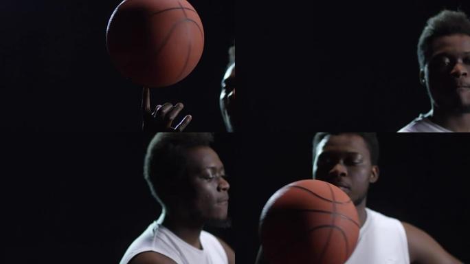 篮球运动员在黑暗背景下旋转球