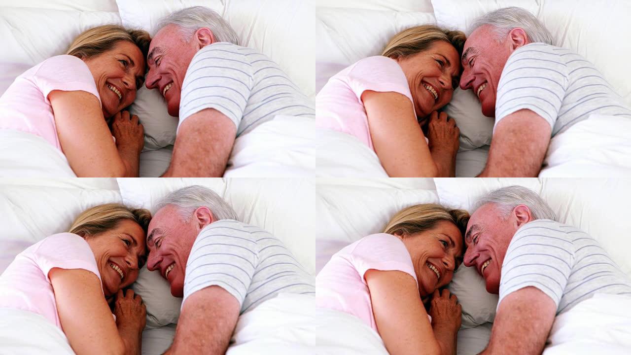 快乐的老年夫妇躺在床上