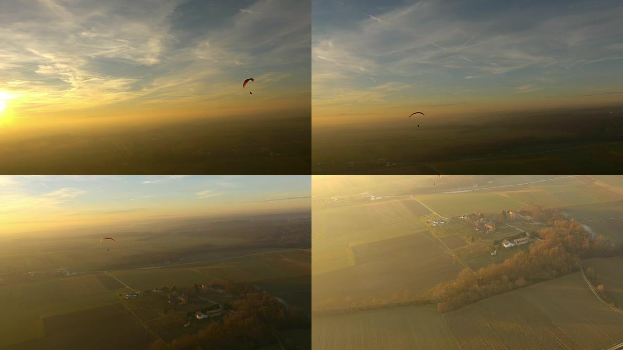 空中无人机的视点跳伞跳伞在阳光明媚的田园诗般的风景上，实时