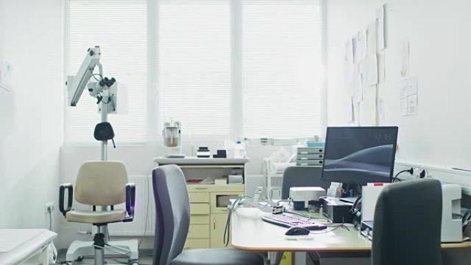 明亮现代的医生办公室，配有个人电脑和耳鼻喉科、眼科设备。