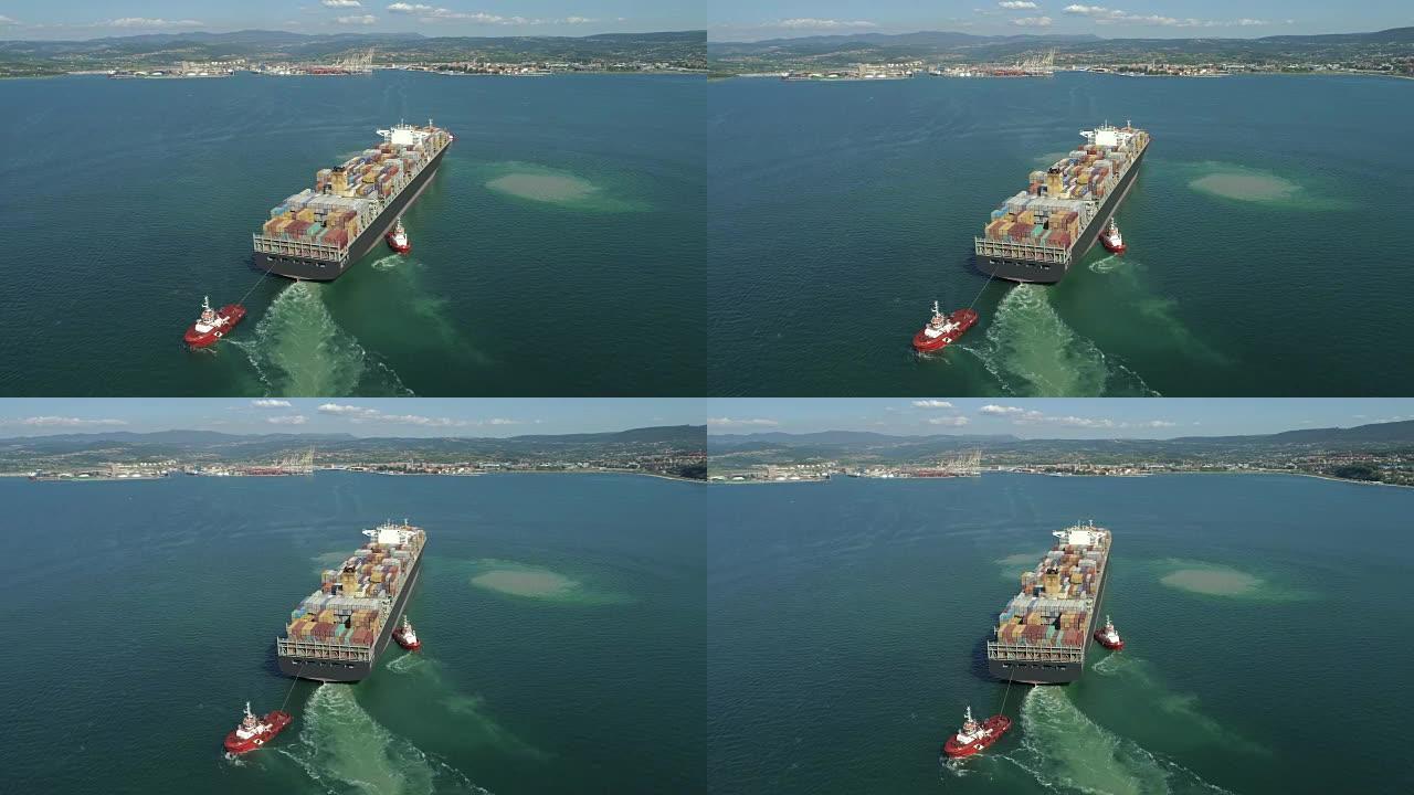 空中: 在大型集装箱船周围飞行，接近海岸上的造船厂。