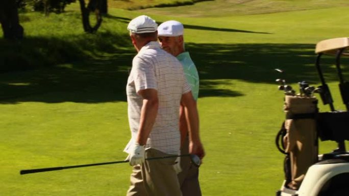 两个男性朋友在高尔夫球场聊天和散步