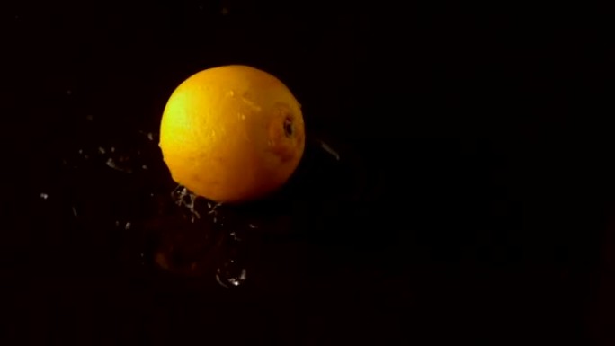 柠檬滴在潮湿的黑色表面上