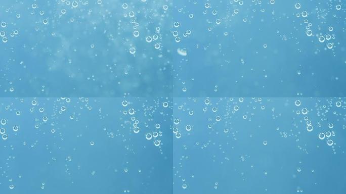 抽象的蓝色背景。通过透明墙壁漂浮的水泡的镜头。淡水概念。