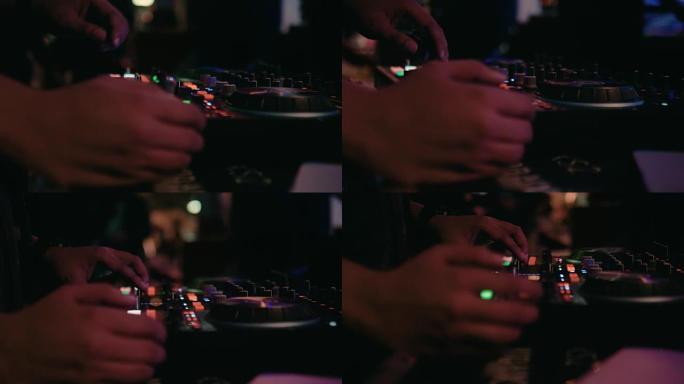 DJ hands的特写镜头在派对上的夜总会舞台上混合了曲目